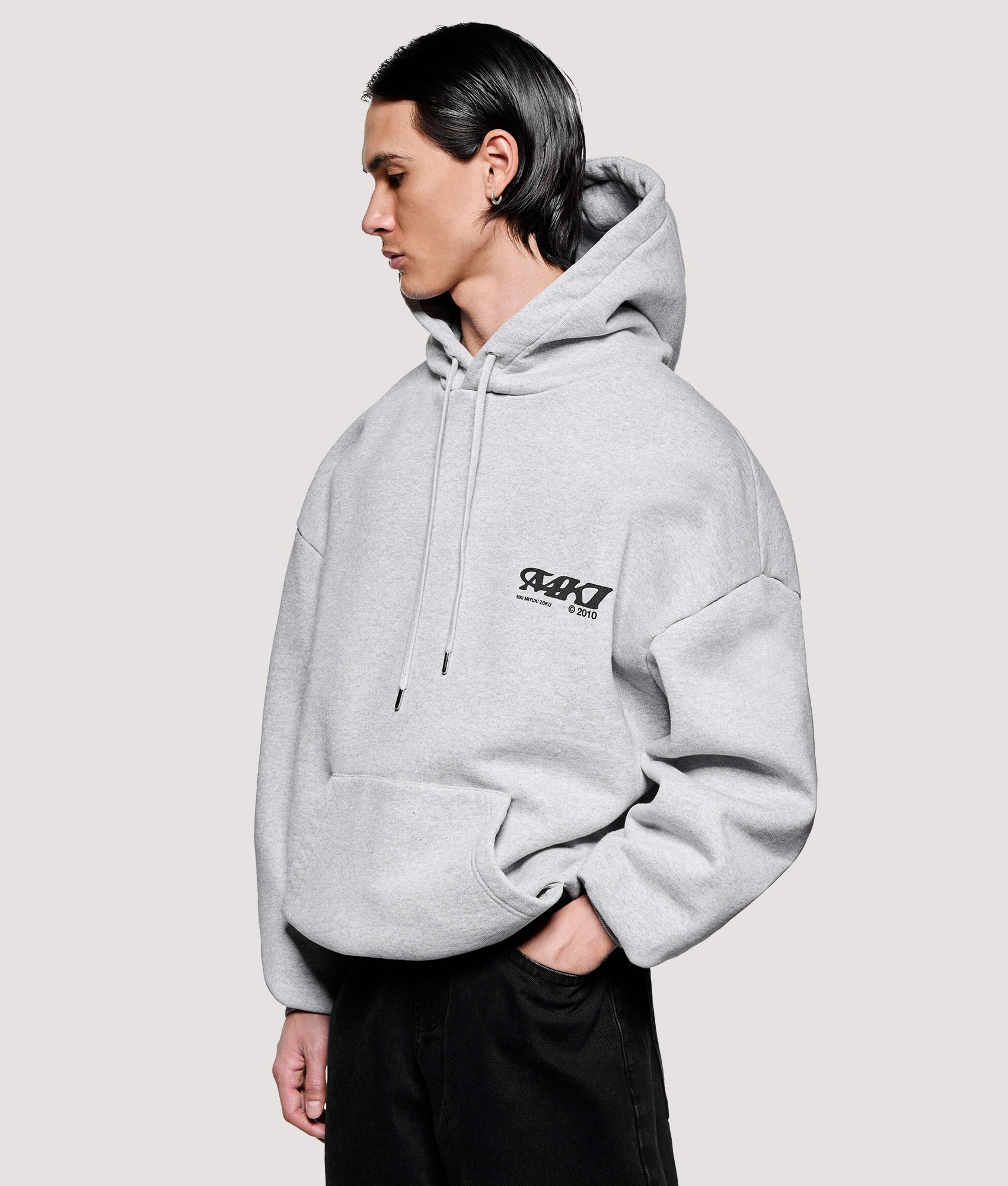 MKI MIYUKI ZOKU Box Fit Stack Hoodie in Grey at EQVVS Menswear. Angled model front shot.