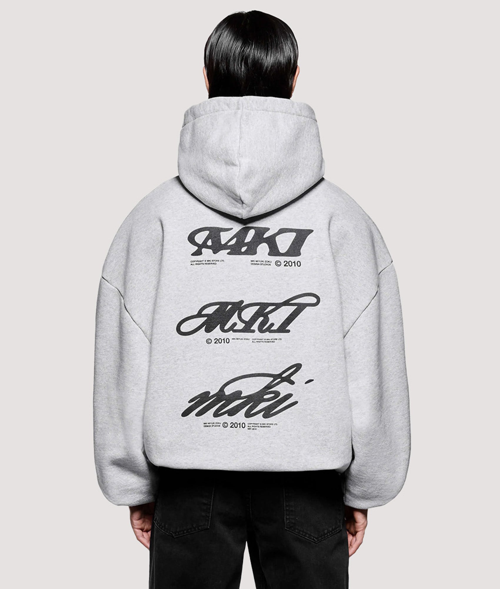 MKI MIYUKI ZOKU Box Fit Stack Hoodie in Grey at EQVVS Menswear. Model back shot.