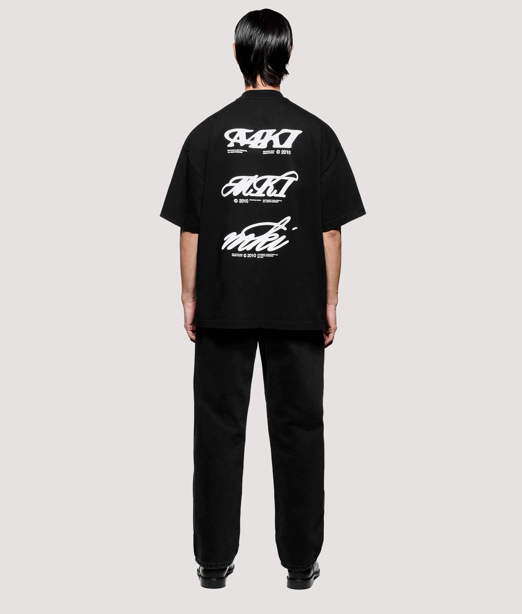 MKI MIYUKI ZOKU Box Fit Flight T-Shirt in Black at EQVVS Menswear. Model full back shot.