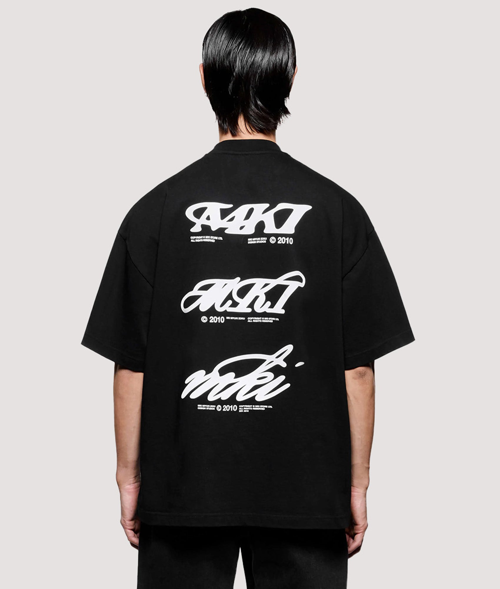 MKI MIYUKI ZOKU Box Fit Flight T-Shirt in Black at EQVVS Menswear. Model back shot.