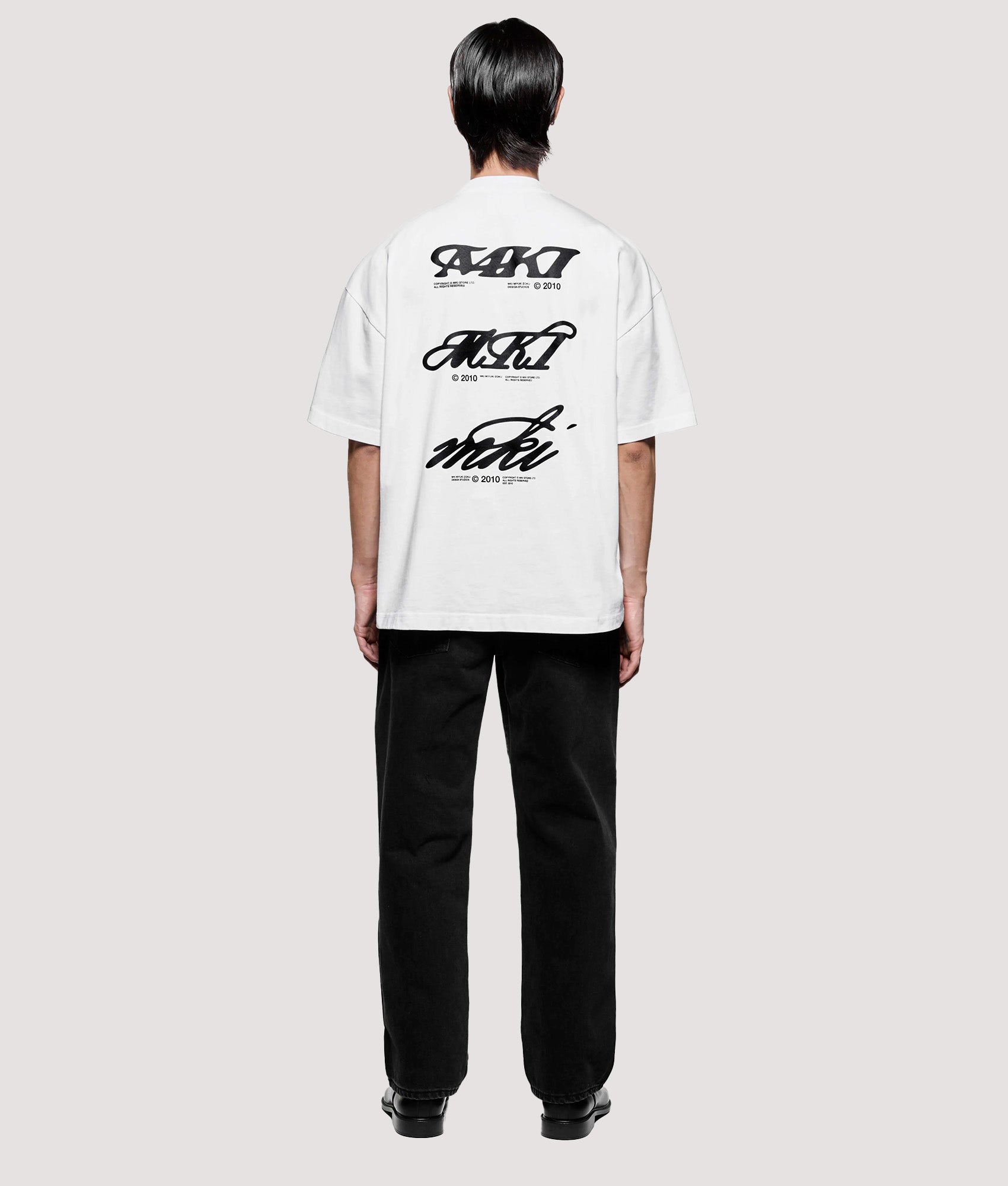 MKI MIYUKI ZOKU Box Fit Flight T-Shirt in White at EQVVS Menswear. Model full back shot.