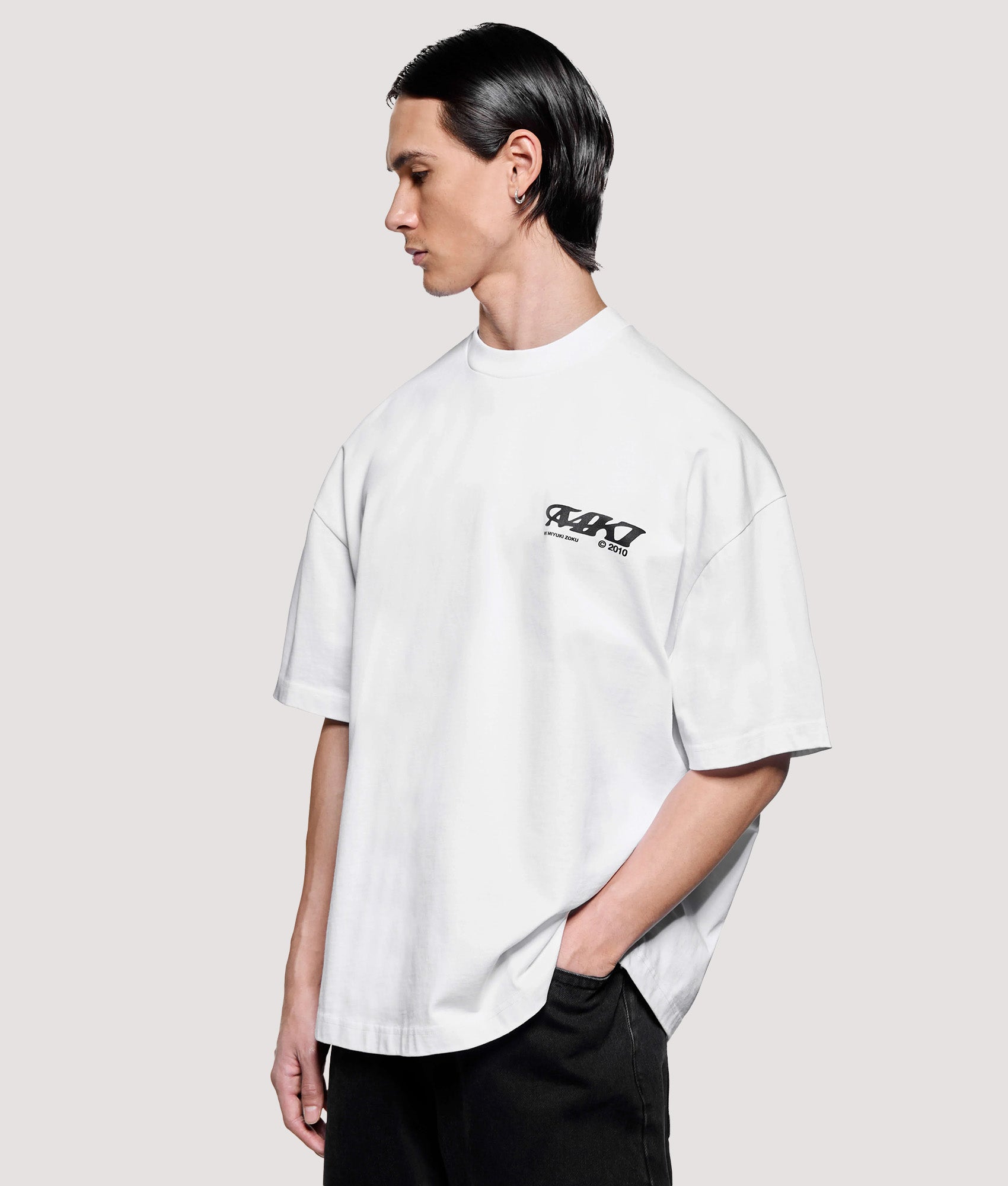 MKI MIYUKI ZOKU Box Fit Flight T-Shirt in White at EQVVS Menswear. Angled model front shot.