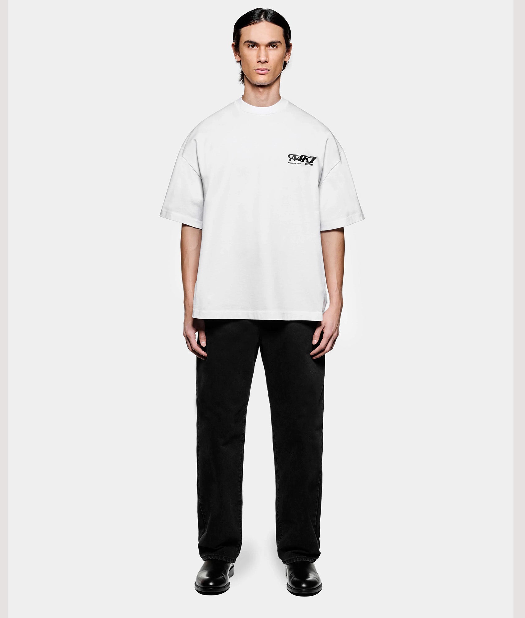 MKI MIYUKI ZOKU Box Fit Flight T-Shirt in White at EQVVS Menswear. Model full front shot.
