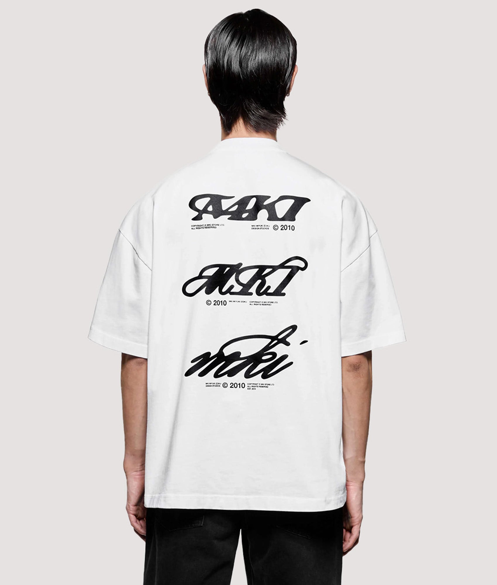 MKI MIYUKI ZOKU Box Fit Flight T-Shirt in White at EQVVS Menswear. Model back shot.