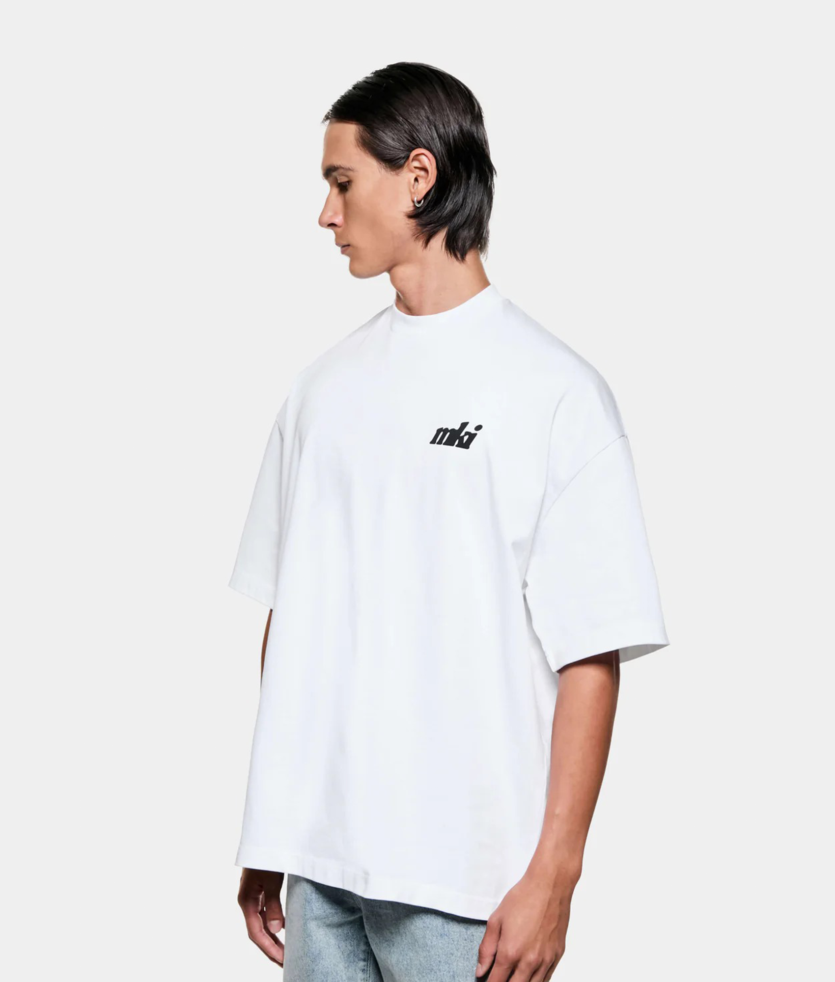 MKI MIYUKI ZOKU Stamp T-Shirt in white at EQVVS Menswear. Angled model front shot.