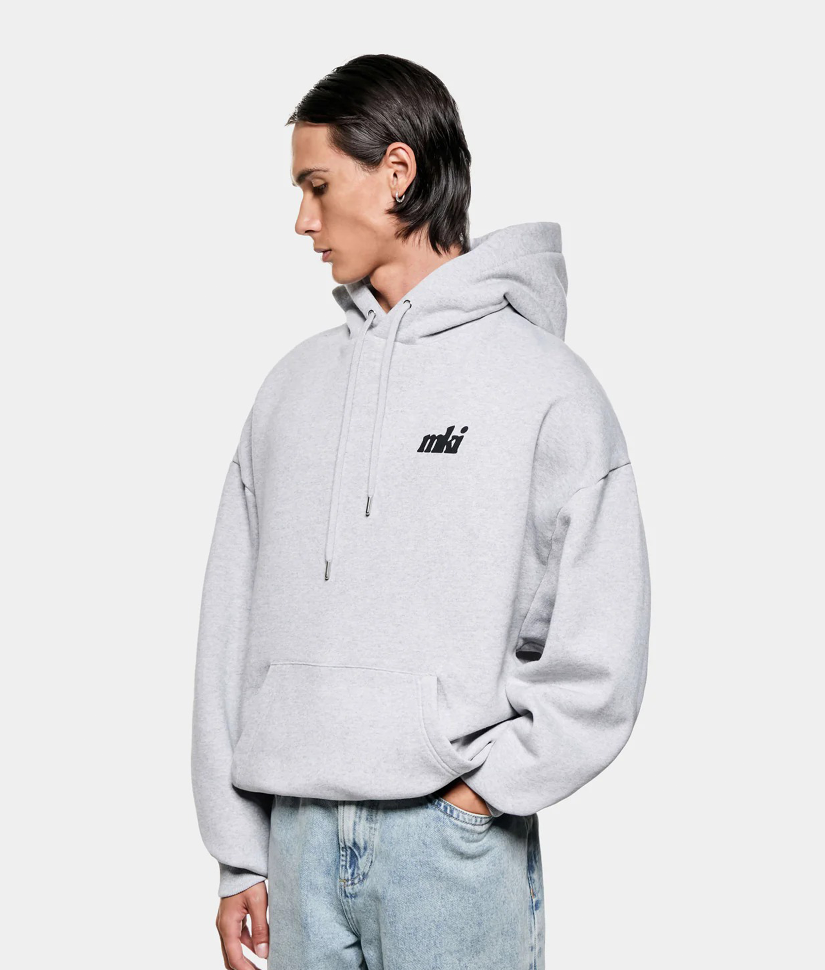 MKI MIYUKI ZOKU Stamp Hoodie in Grey at EQVVS Menswear. Angled model front shot.