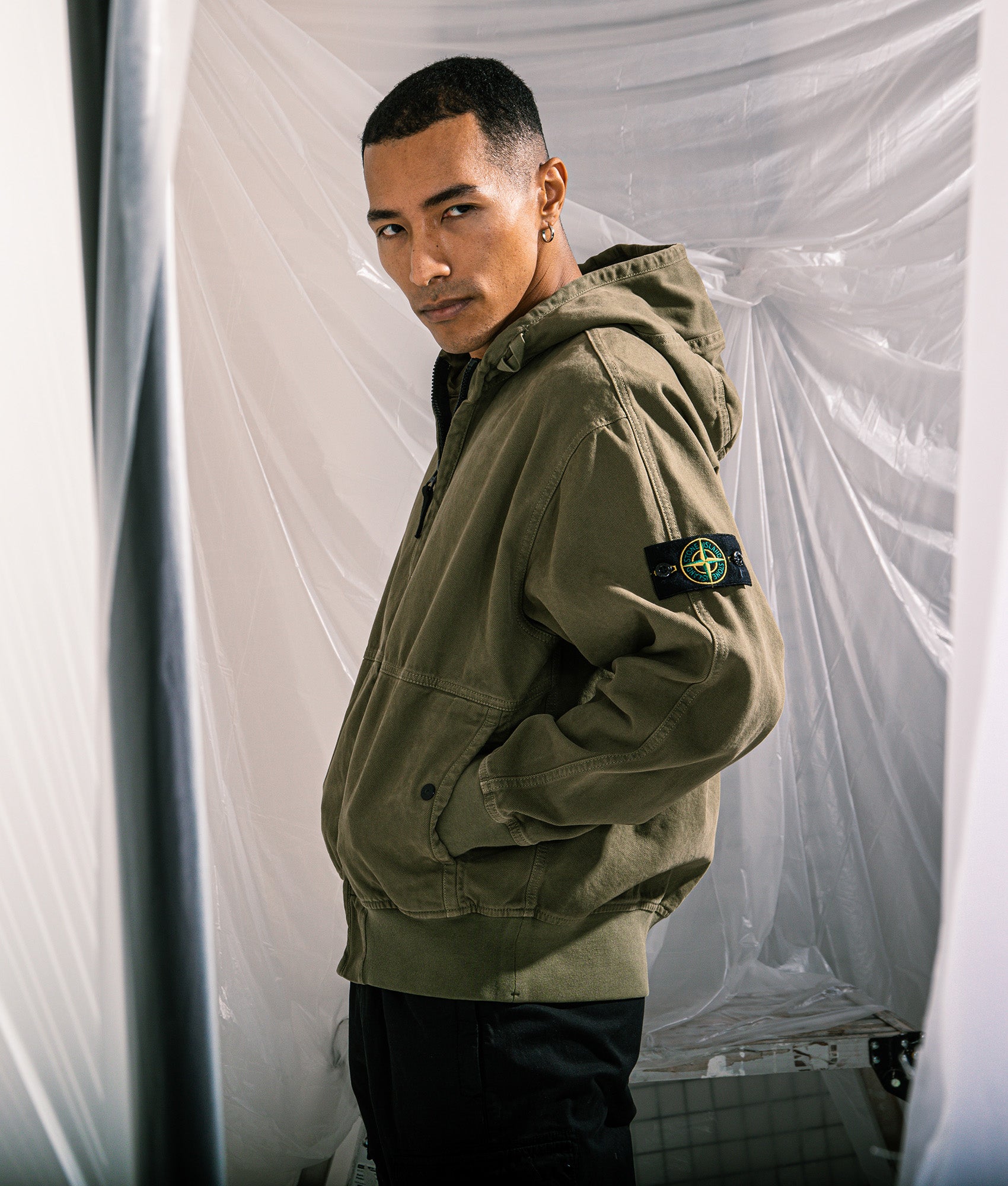 Stone Island Relaxed Fit Panama ‘Old’ Effect Zip Through Hoodie in Military Green at EQVVS Menswear. Campaign shot.