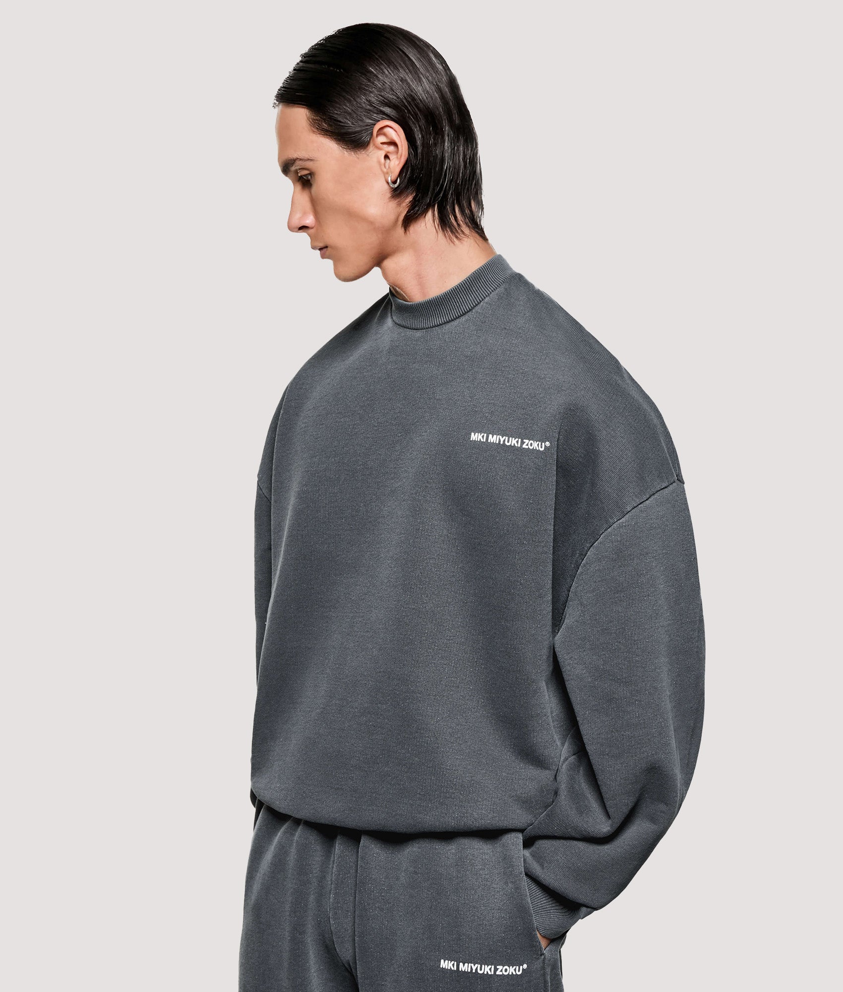MKI MIYUKI ZOKU Box Fit Uniform Crewneck Sweatshirt in Pigment Black at EQVVS Menswear. Angled model front shot.