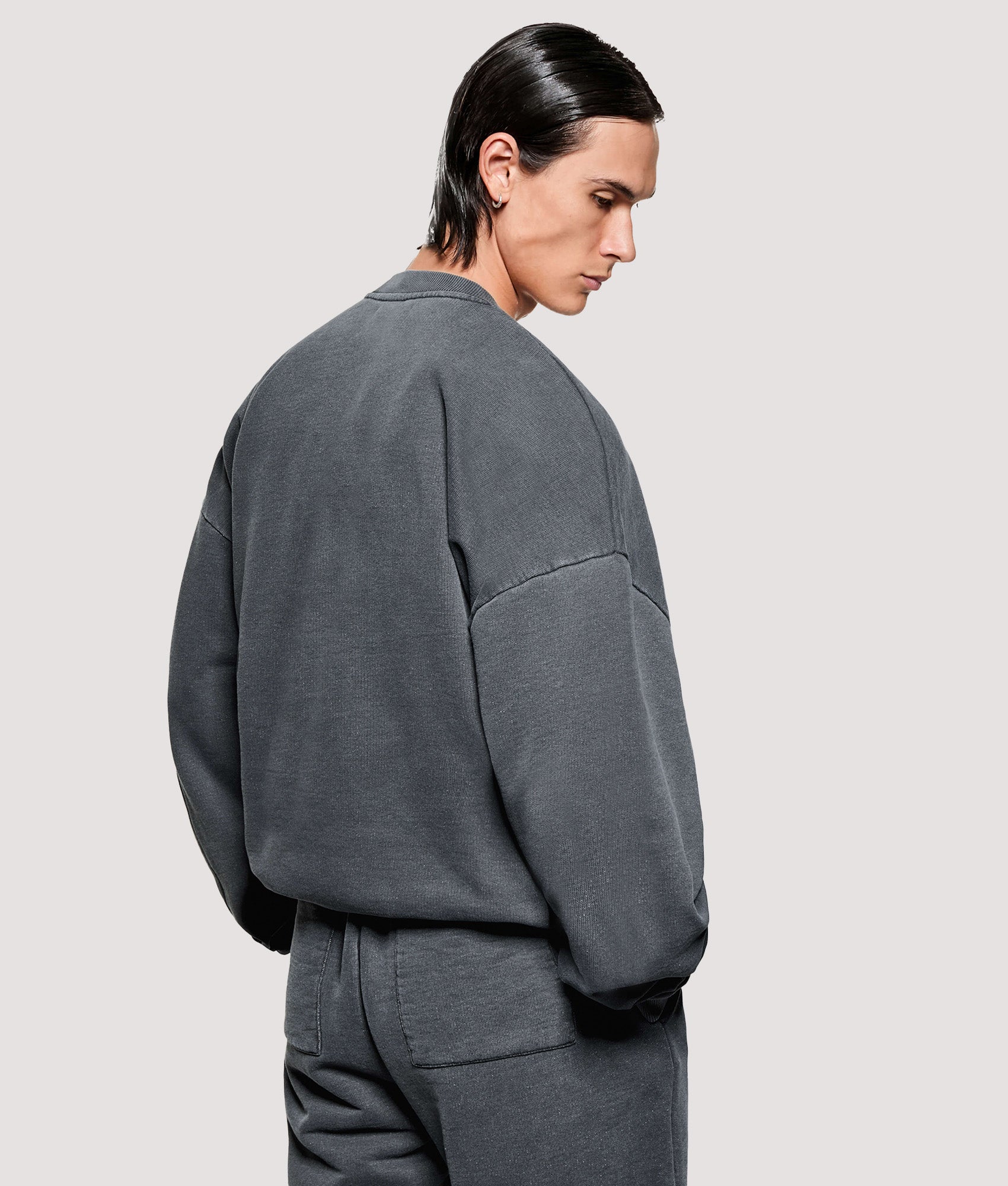 MKI MIYUKI ZOKU Box Fit Uniform Crewneck Sweatshirt in Pigment Black at EQVVS Menswear. Angled model back shot.