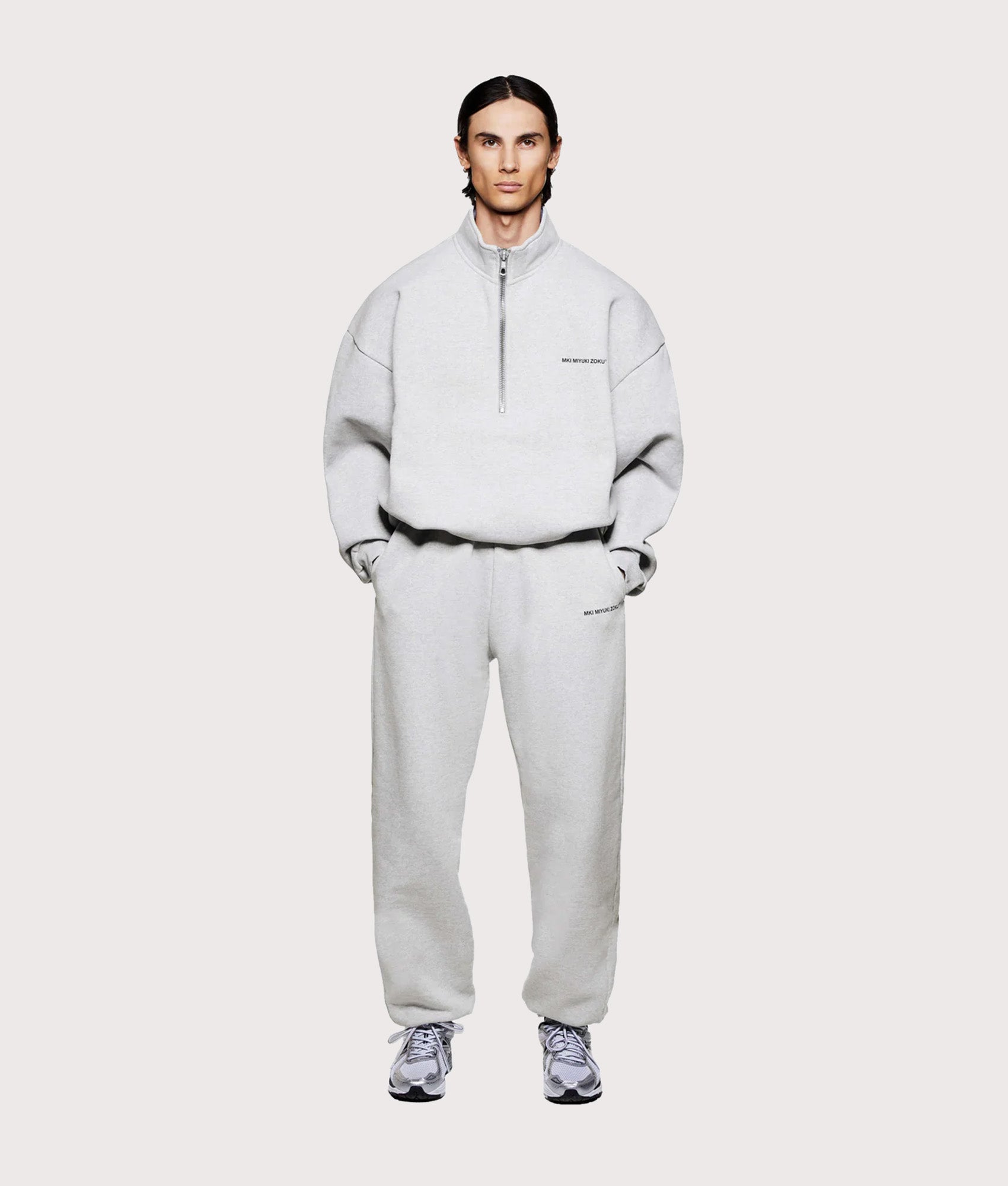 MKI MIYUKI ZOKU Oversized Uniform Quarter Zip Sweatshirt in Grey at EQVVS Menswear. Model full front shot.