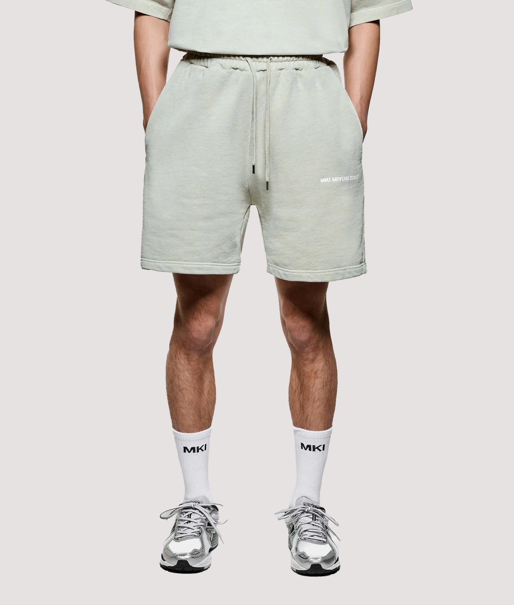 MKI MIYUKI ZOKU Relaxed Fit Uniform Shorts in Pigment Cement at EQVVS Menswear. Model front shot.