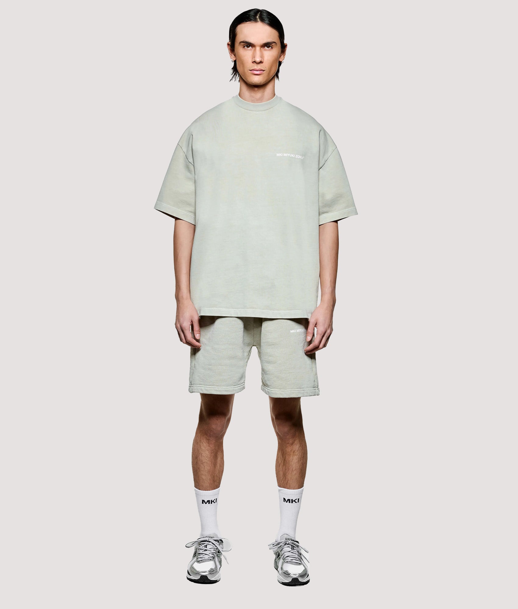 MKI MIYUKI ZOKU Box Fit Uniform T-Shirt in Pigment Cement at EQVVS Menswear. Model full front shot.