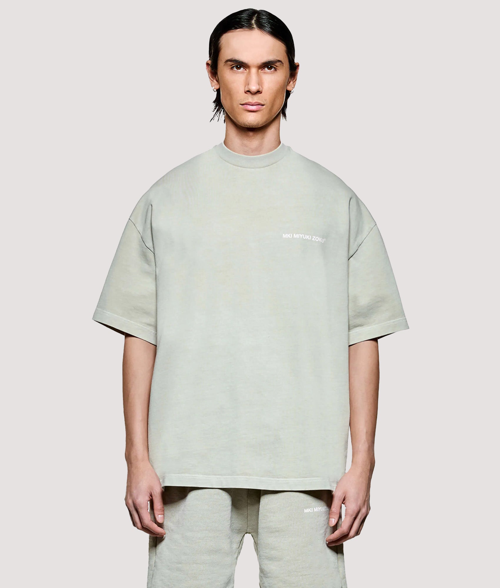 MKI MIYUKI ZOKU Box Fit Uniform T-Shirt in Pigment Cement at EQVVS Menswear. Model front shot.