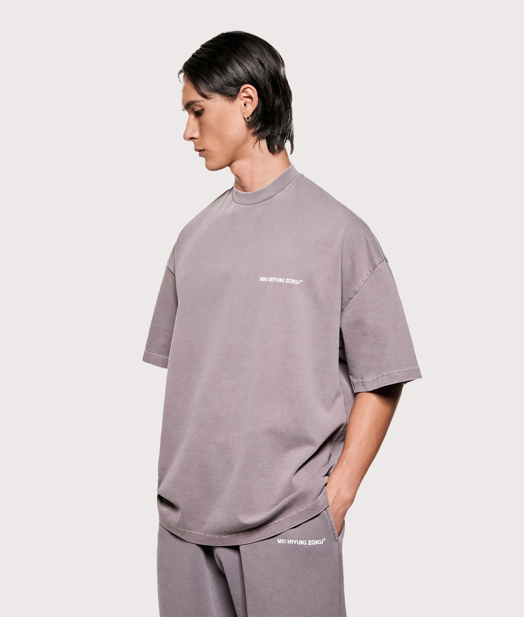 MKI MIYUKI ZOKU Oversized Uniform T-Shirt in Pigment Raisin at EQVVS Menswear. Angled model front shot.