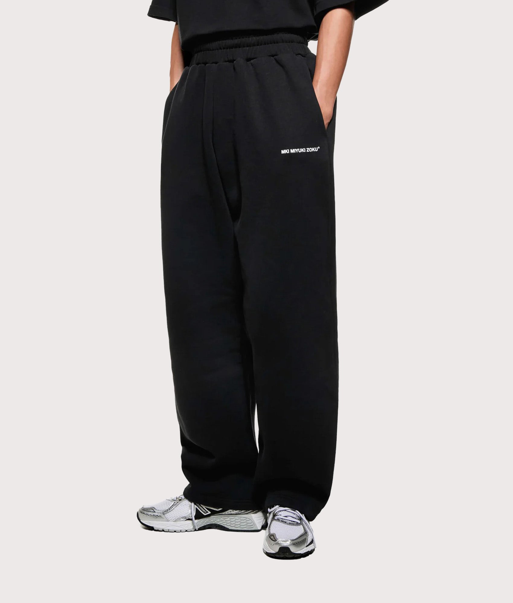 MKI MIYUKI ZOKU Uniform Wide Leg Joggers in Black at EQVVS Menswear. Angled model front shot.