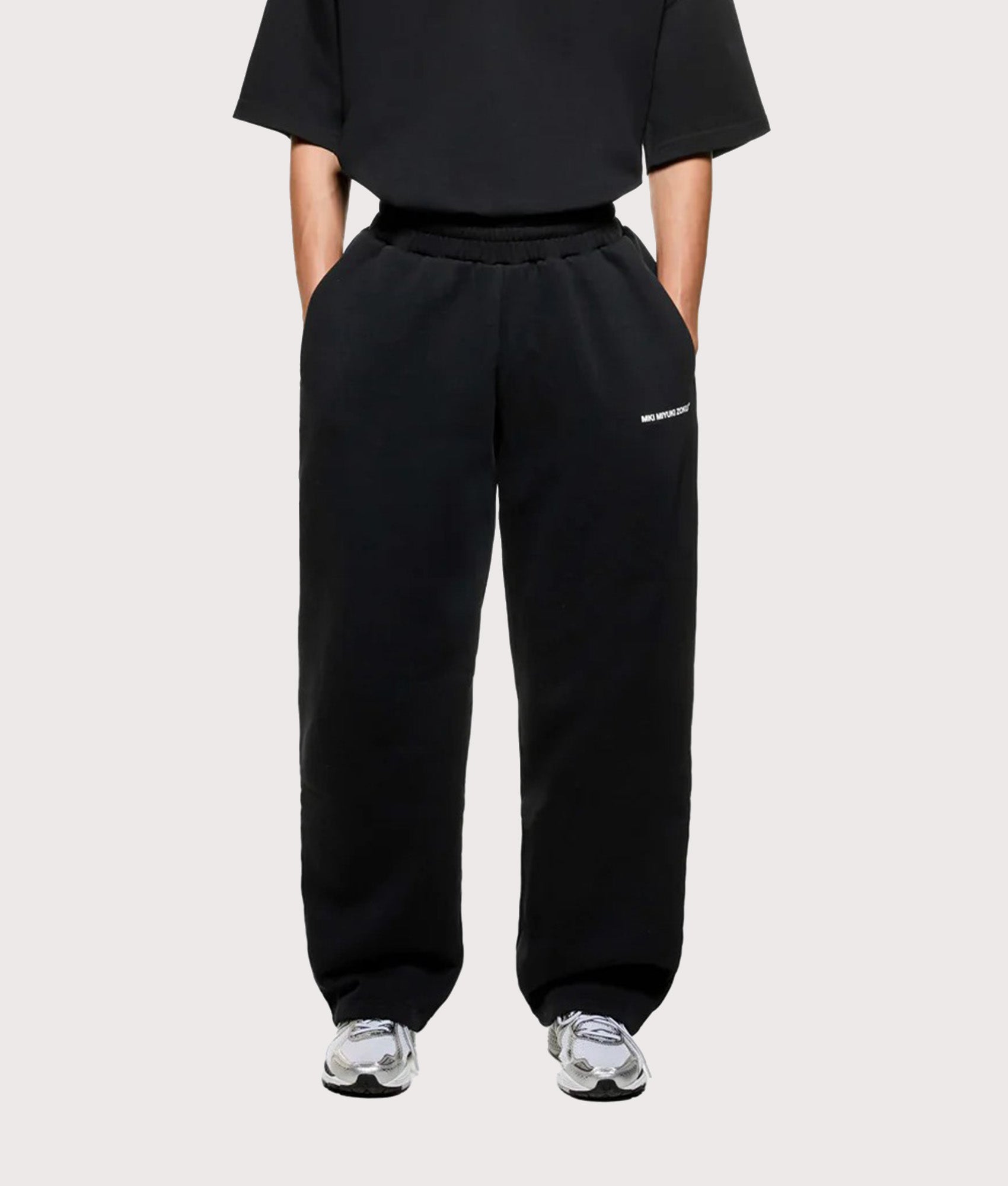 MKI MIYUKI ZOKU Uniform Wide Leg Joggers in Black at EQVVS Menswear. Model front shot.