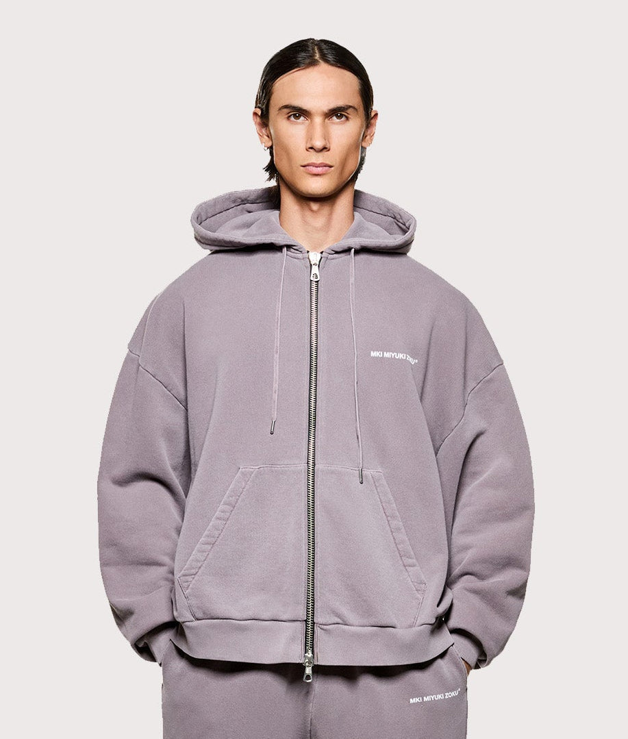 MKI MIYUKI ZOKU Uniform Zip Through Hoodie in Pigment Raisin at EQVVS Menswear. Model full front shot.