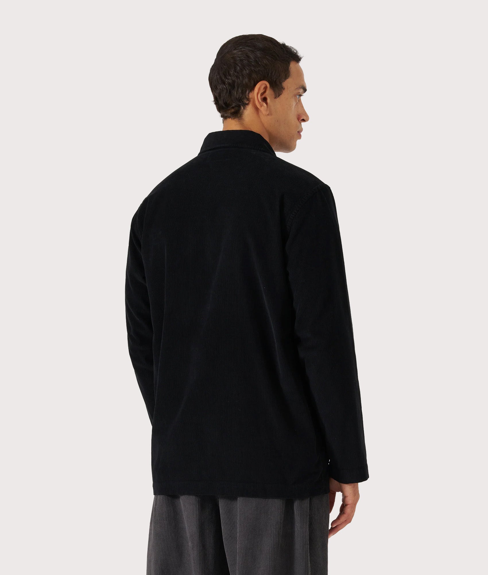Universal Works Bakers Overshirt in Black at EQVVS Menswear. Model back shot.