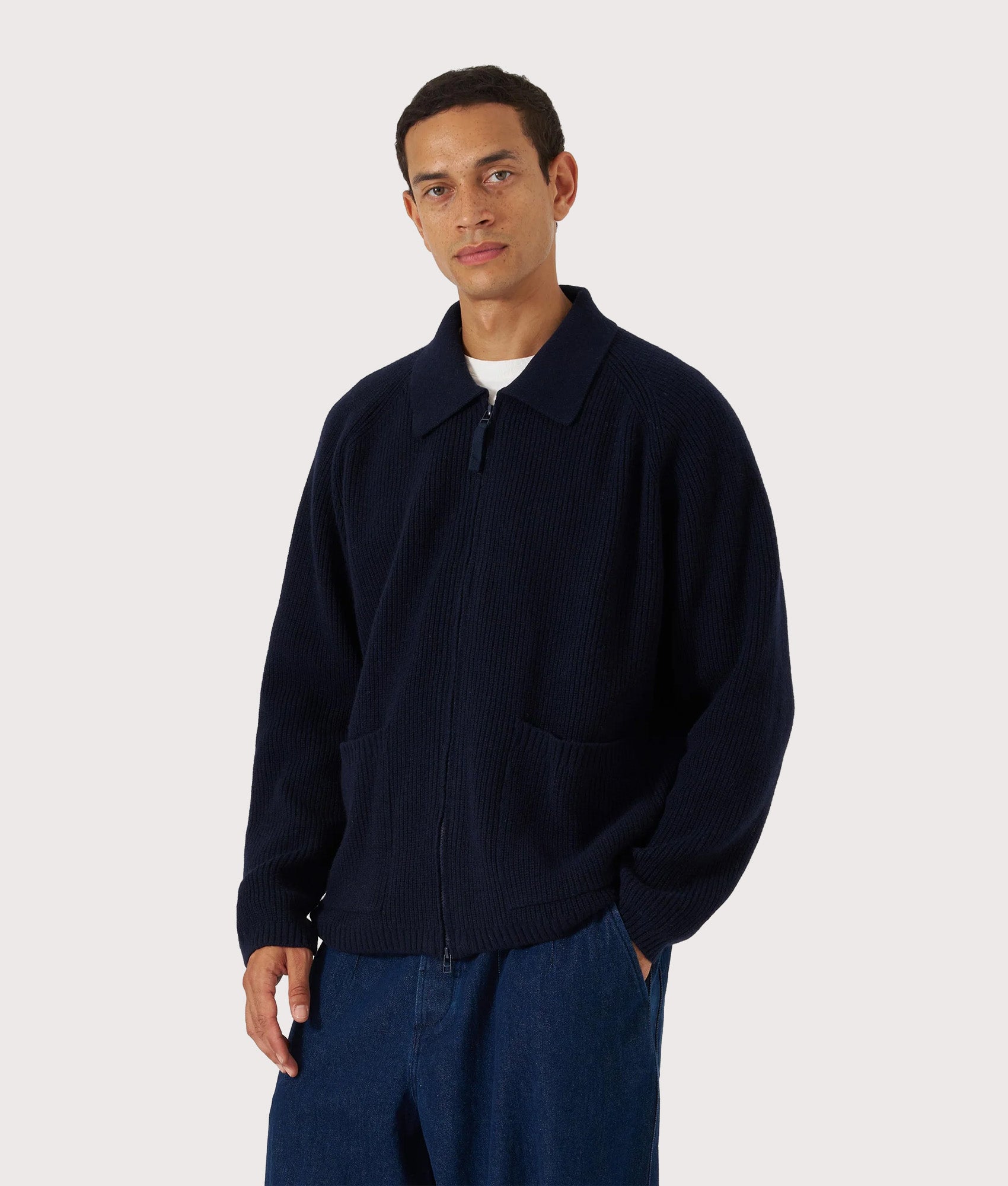 Universal Works Relaxed Fit Wool Zip Cardigan in Navy at EQVVS Menswear. Model front shot.