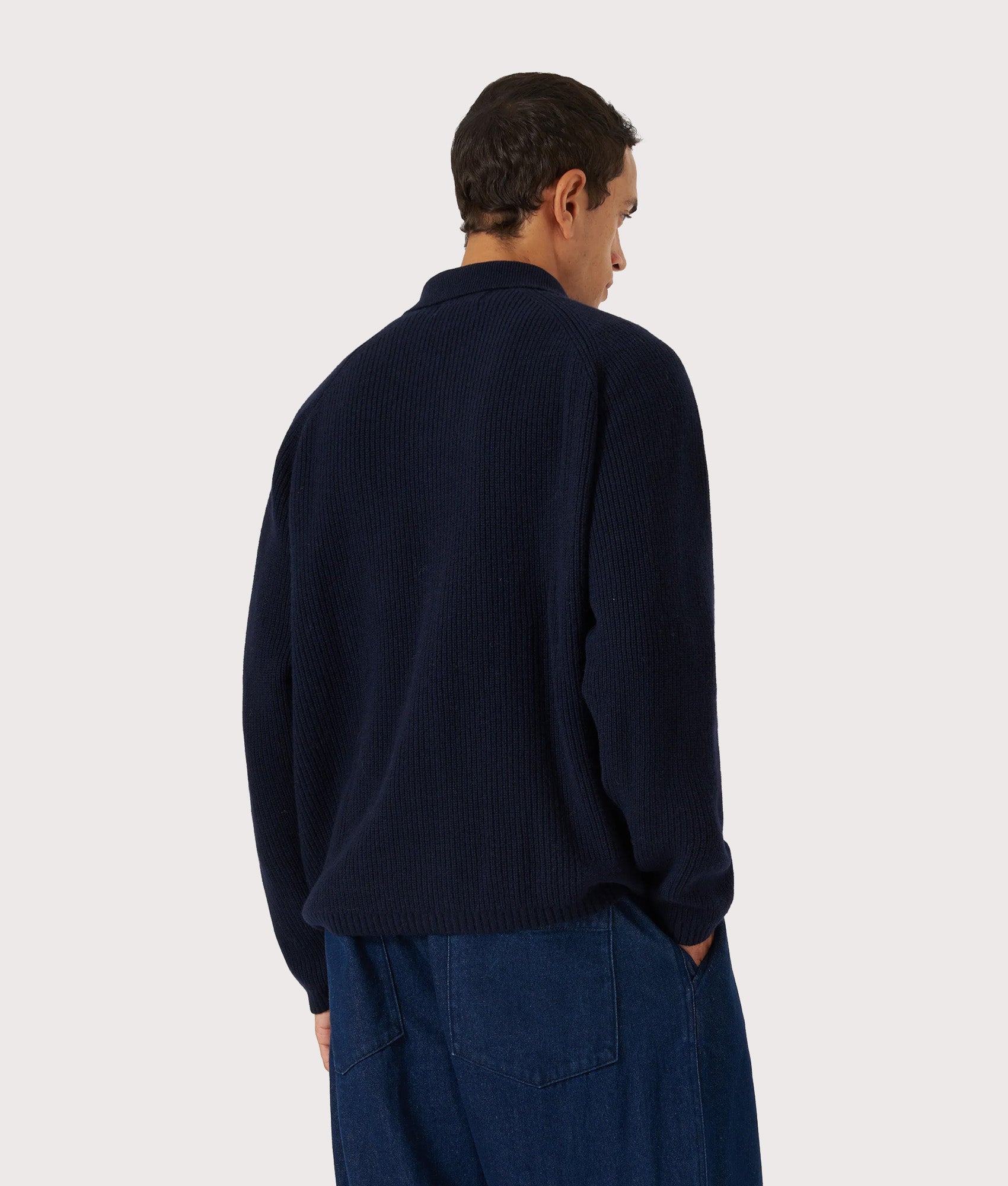 Universal Works Relaxed Fit Wool Zip Cardigan in Navy at EQVVS Menswear. Model Back shot.