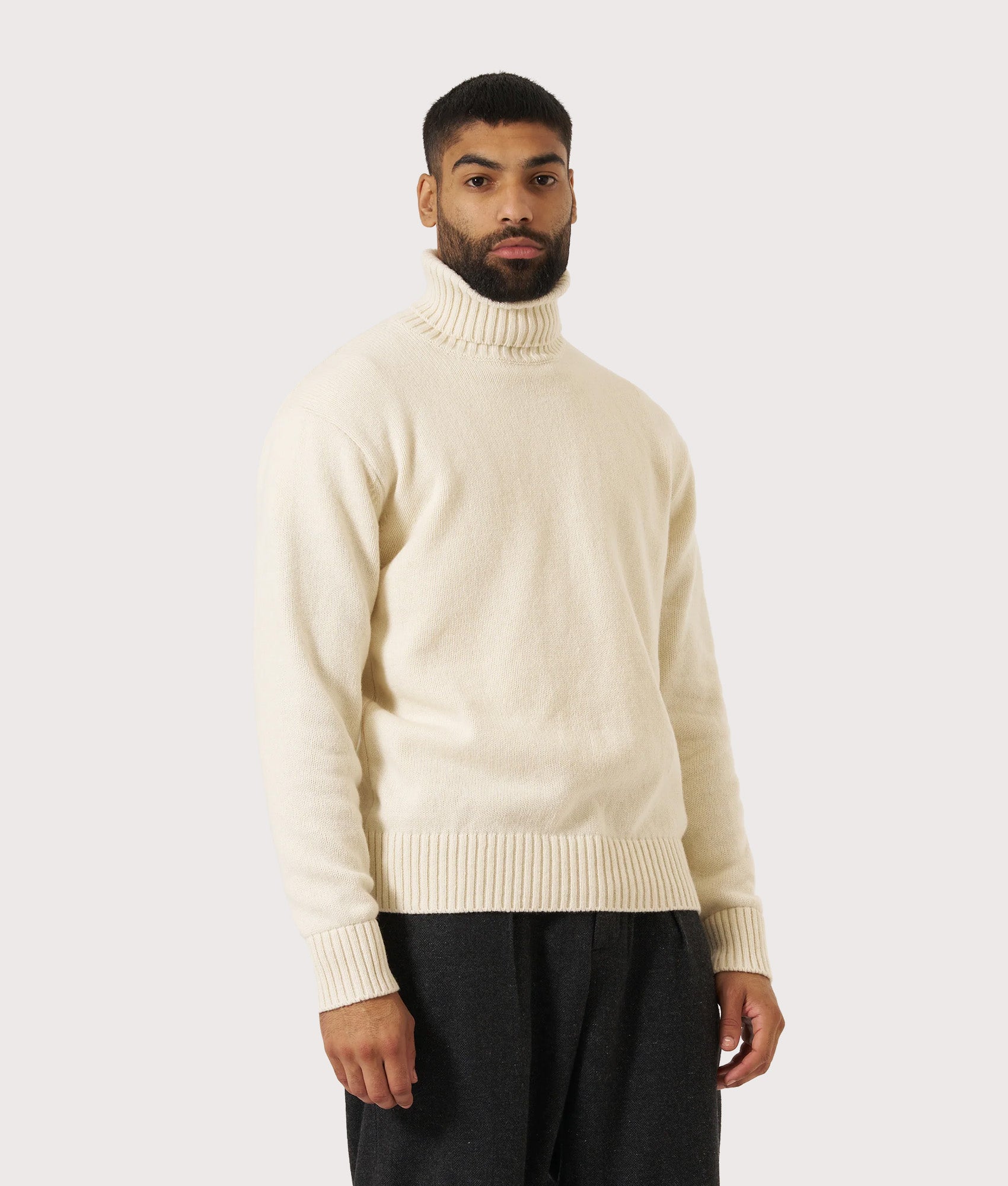 Universal Works Roll Neck Sweatshirt in Ecru at EQVVS Menswear. Model front shot.
