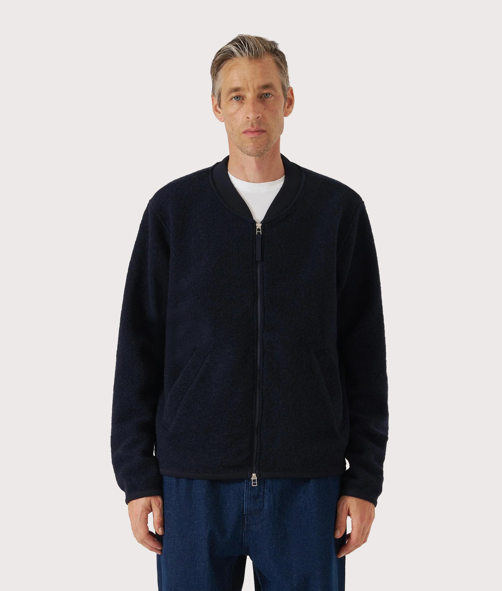 Universal Works Wool Zip Bomber Jacket in Navy at EQVVS Menswear. Model front shot.