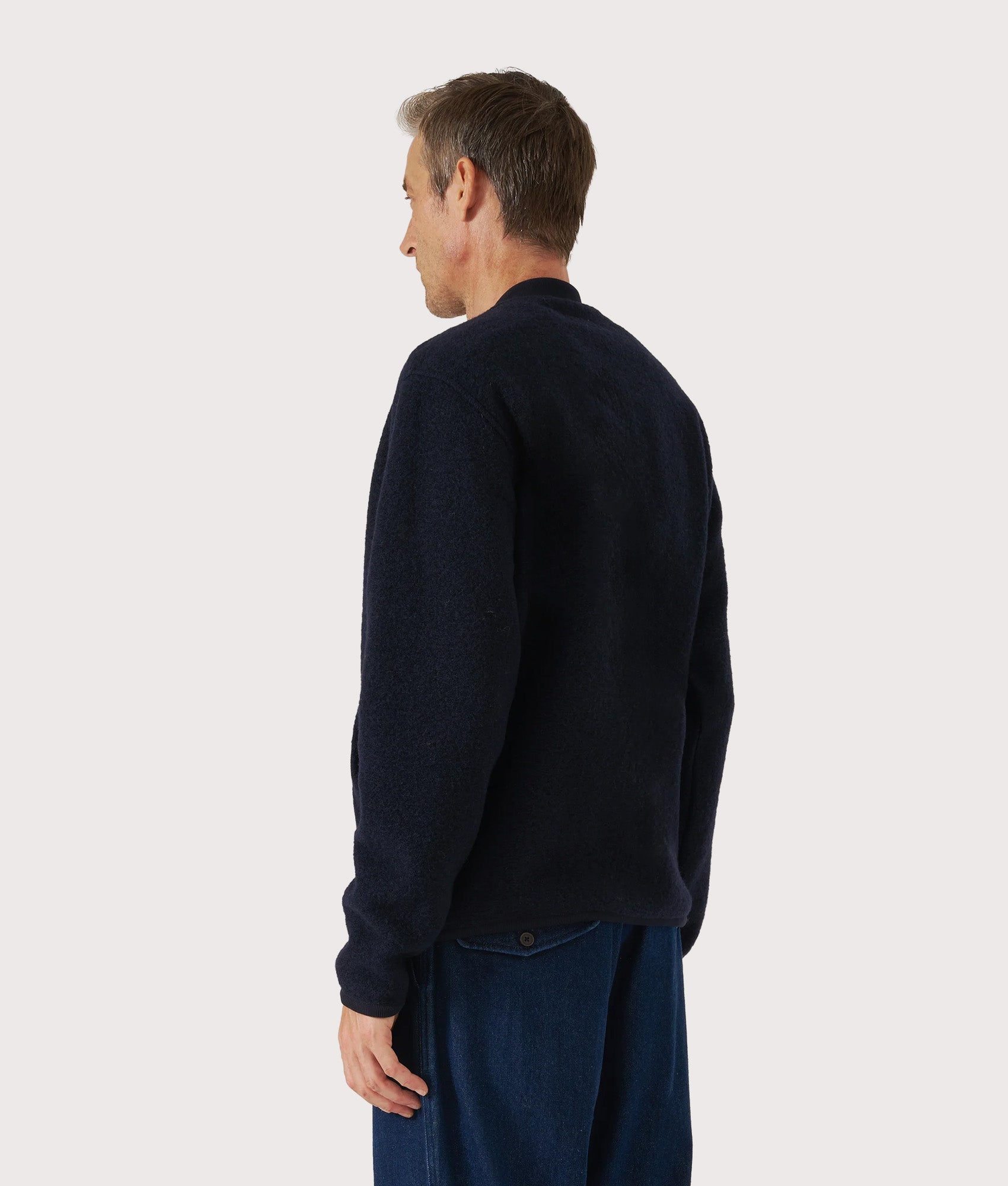 Universal Works Wool Zip Bomber Jacket in Navy at EQVVS Menswear. Angled back shot.