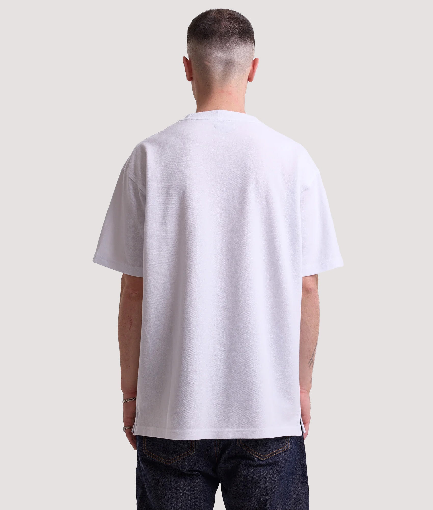 Rockport Relaxed Fit Rocester Piqué Logo T-Shirt in White at EQVVS Menswear. Model back shot.