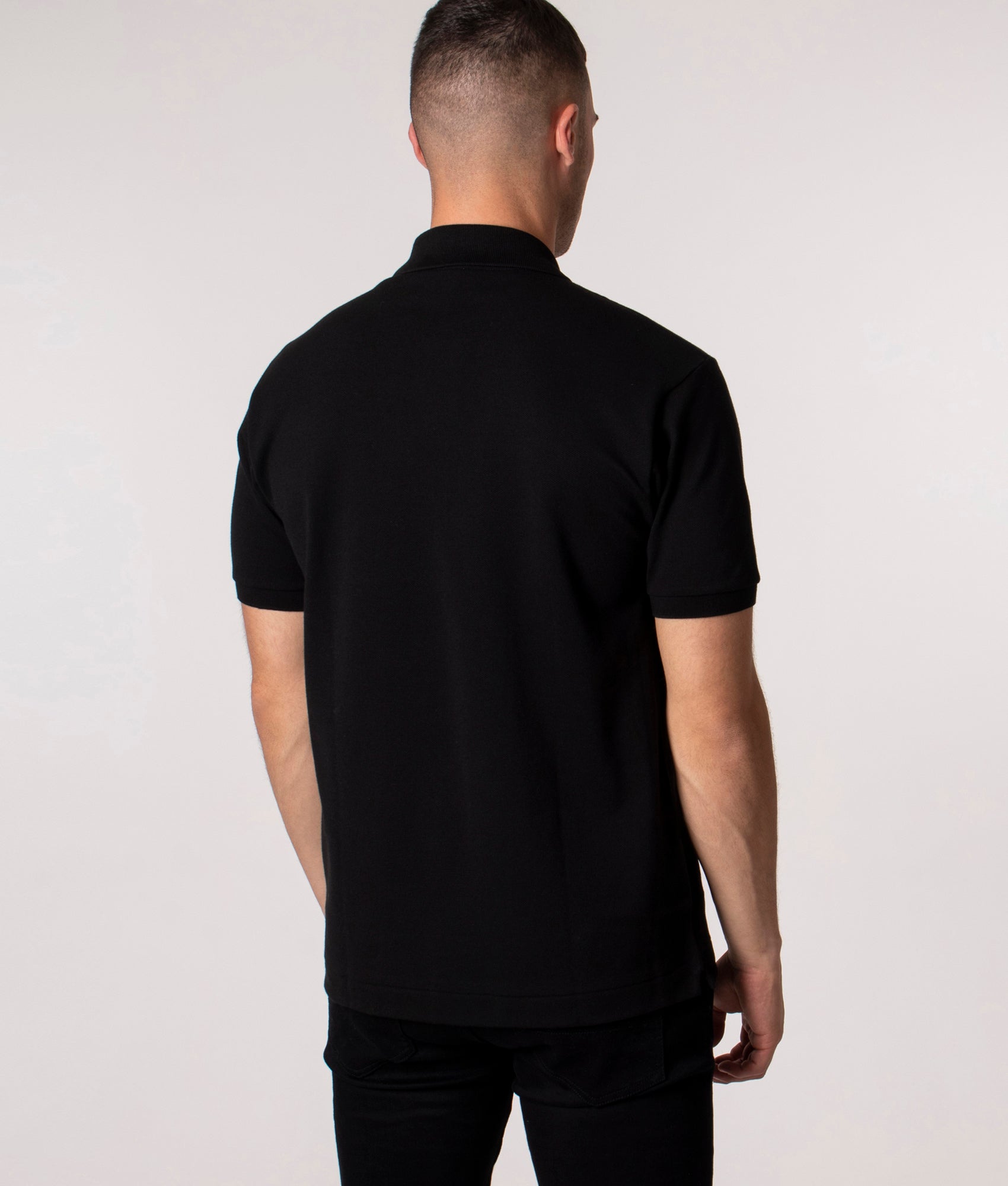 Lacoste Classic Fit L1212 Croc Logo Polo Shirt in Black at EQVVS Menswear. Model back shot. 