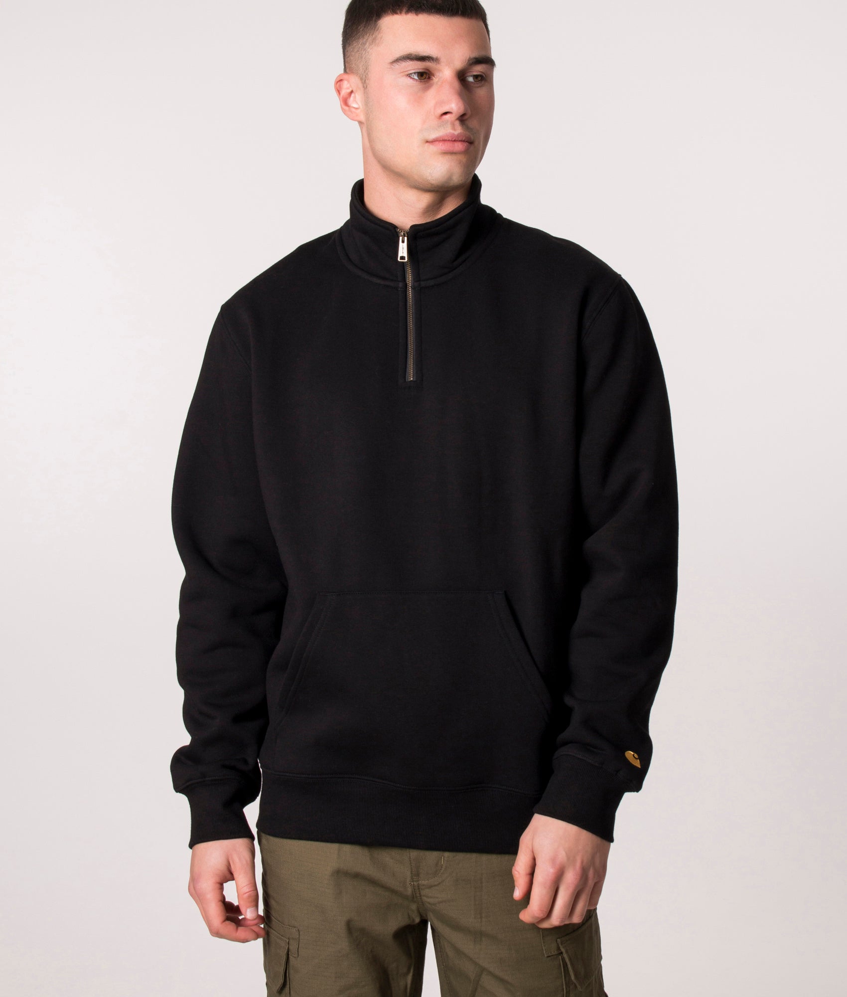 Carhartt WIP Quarter Zip Chase Sweatshirt in Black and Gold at EQVVS Menswear. Model front shot.