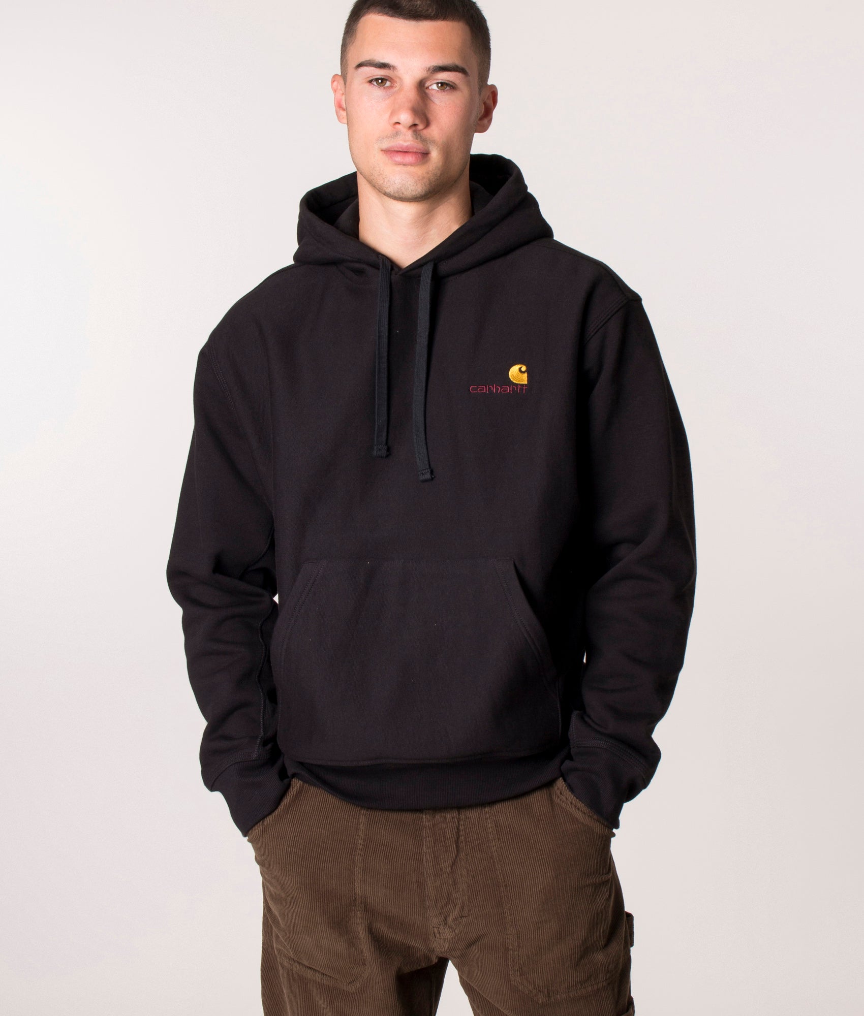 Carhartt WIP Loose Fit American Script Hoodie in Black at EQVVS Menswear. Model front shot.