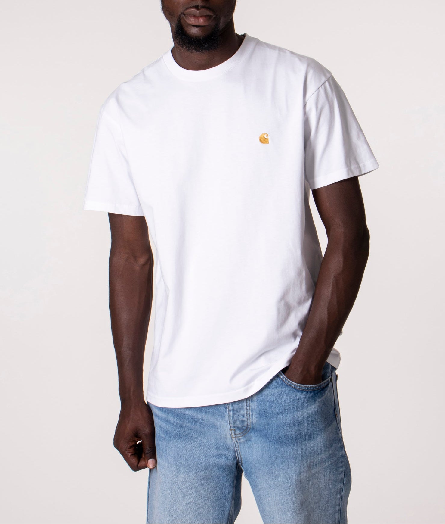 Carhartt WIP Loose Fit Chase T-Shirt in White/Gold at EQVVS Menswear. Model front shot.